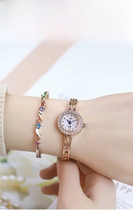 Detailed view of women's gold quartz watch and colorful gemstone bangle set on wrist