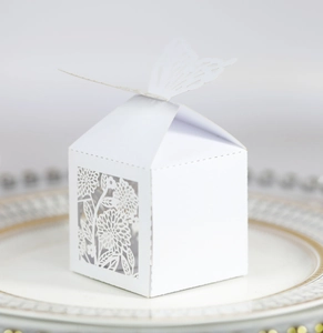 Detail of white butterfly wedding candy box with intricate laser-cut floral patterns