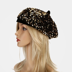 Detail view of a black sequin beret with shiny gold circular sequins on a model