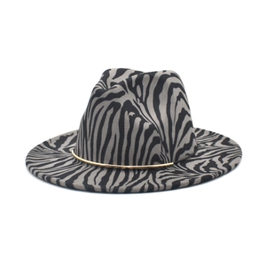 Close-up of zebra pattern wool fedora hat featuring a stylish gold metal tube trim