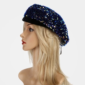 Close-up detail of shimmering blue sequins on a stylish beret with black velvet trim