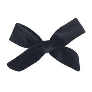 Detailed view of the soft texture and glossy finish of a black velvet ribbon bow accessory