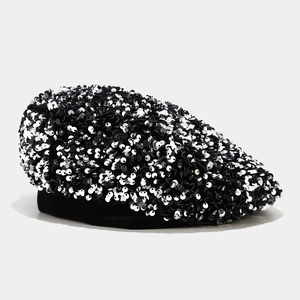 Detailed view of shimmering black and silver sequins on a stylish women's beret hat