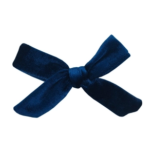Detail view of handmade navy blue velvet knot bow hair accessory with soft texture