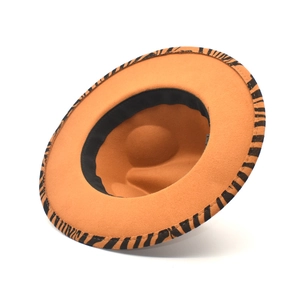 Detail shot of tan fedora hat with zebra pattern brim and black inner sweatband