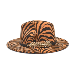 Women's zebra print fedora hat in orange and black with golden feather accessory