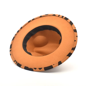 Detail of winter fedora interior featuring orange felt material and black patterned lining