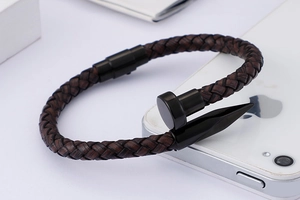Close-up of woven dark brown leather cord with a black metal nail-shaped clasp detail