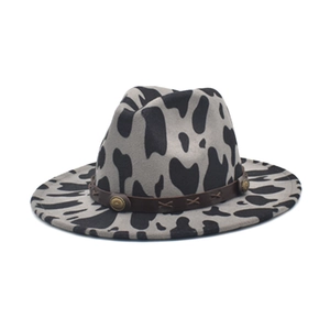 Detail of cow print fedora with brown leather band and decorative metal conchos