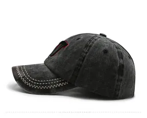 Detailansicht der verwaschenen Baseballkappe mit roter Stickerei und Ziernähten an der Krempe