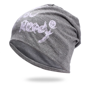 Détail macro du bonnet en tricot gris montrant le coton doux et l'imprimé violet Ready