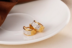 Detail of 18K gold plated stainless steel huggie earrings with pavé-set clear crystals