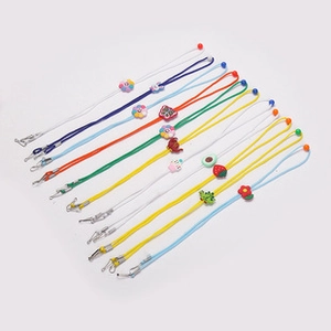 Colorful lanyards with floral charms and metal clips on a clean gray background