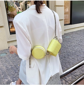 Detail of yellow crocodile pattern mini chain bag set on white blazer background