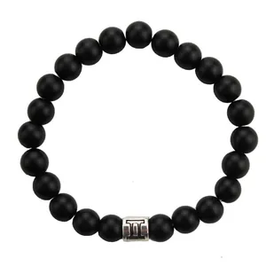 Close-up of 8mm matte black beads bracelet featuring a silver Gemini zodiac charm