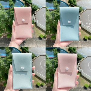 Outdoor shot of pink and light blue PU leather eyeglass pouches with snap closure