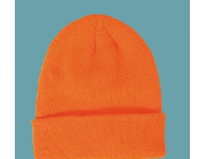 Detail view of bright orange knitted cuffed beanie hat against a blue backdrop