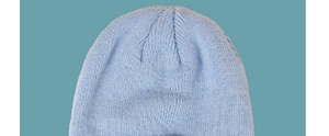 Close-up detail of light blue knitted hat showing the fine V-shaped textured stitching