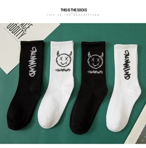 Détail de quatre chaussettes en coton noir et blanc avec graffiti CALMIND et diablotin