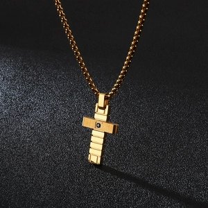 Detailed view of a gold cross pendant with black zircon stones on a box chain
