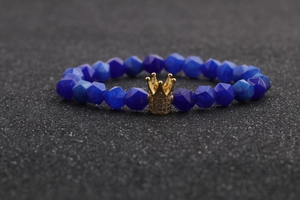 Macro view of blue faceted agate bead bracelet with a gold crown charm detail