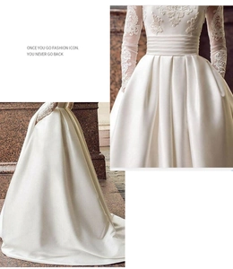 Detail of white long sleeve wedding dress with lace embroidery and satin pleated skirt
