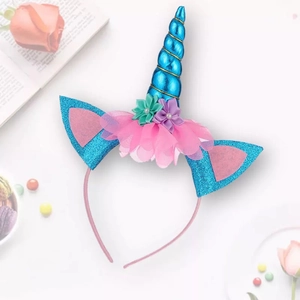 Detail of pink unicorn headband with a blue glitter horn and colorful tulle flowers
