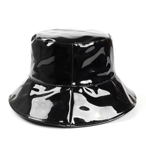 Vista dettagliata della texture in pelle PU nera lucida su un cappello a secchiello a tesa larga