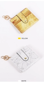Detail of yellow and white marble texture card holders with golden keychain and buckle