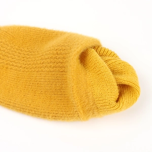 Detail of yellow knit hat featuring fuzzy faux mink texture and golden metallic yarn