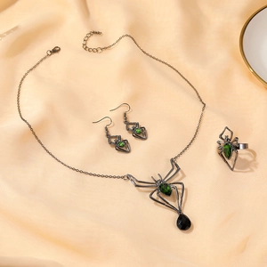Macro detail of Halloween spider jewelry set with green crystals on yellow silk
