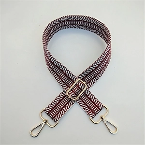 Close-up of red and white geometric woven strap with gold metal lobster clasps