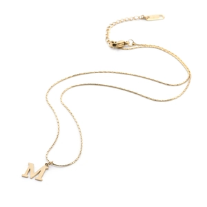 Minimalist gold titanium steel necklace with M letter pendant on a white background