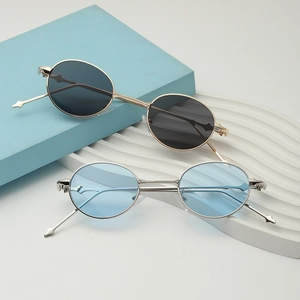 Retro oval metal sunglasses with gold black and silver blue lenses on a deco stand