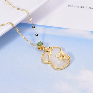 Détail du pendentif lotus en jade blanc sur collier plaqué or 18 carats avec serrure ruyi