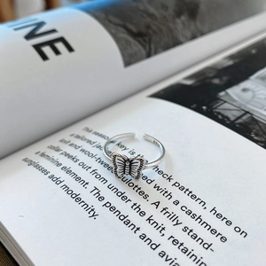 Macro shot of S925 sterling silver butterfly ring with vintage textures on a magazine