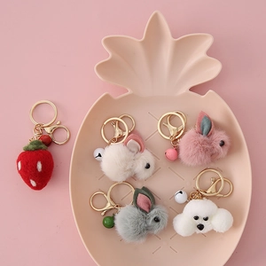 Cute cartoon plush teddy rabbit keychain set on a pink tray with golden bells and hooks