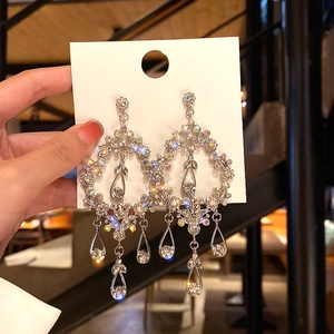 Detailed view of silver hoop earrings with butterfly crystals and long tassels
