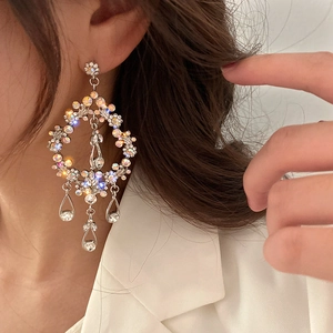 Close-up of silver long hollow teardrop earrings with crystals worn by a model