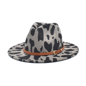 Gray cow print wide brim fedora hat with a brown leather band and gold buckle detail