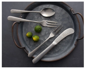 Close-up of matte stainless steel cutlery set with vintage snowflake silver finish