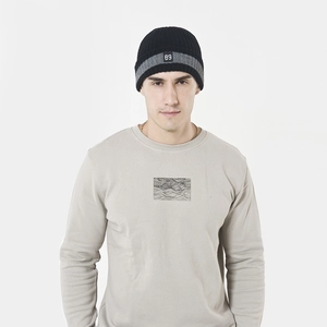 Détail du bonnet en tricot noir avec rayures grises et écusson blanc numéro 89 devant