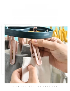 Detail of 12-clip plastic laundry rack showing sturdy windproof clips holding socks