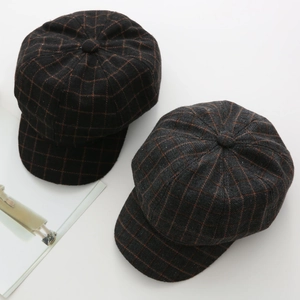 Detail view of vintage plaid wool newsboy caps in black and grey textured fabric