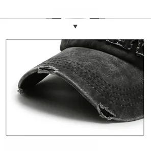 Detail of distressed brim on washed black denim baseball cap with inner shaping layer