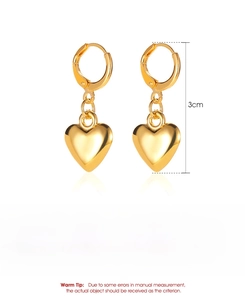 Détail de boucles d'oreilles cœur dorées montrant le fini poli et la dimension de 3 cm