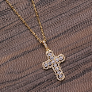 Hip hop gold cross pendant necklace with round zircons on a dark wood background