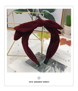 Detailed close-up of a double-layered burgundy velvet bow headband for autumn winter