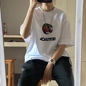 Selfie miroir montrant la coupe d'un t-shirt blanc à logo 404MOB avec graphique
