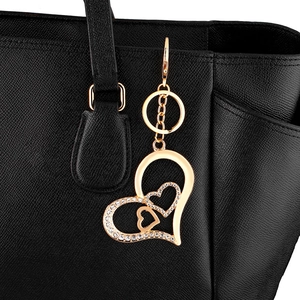 Sparkling rhinestone heart keychain for women handbags in gold finish on black leather bag